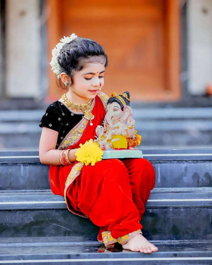 Jovem em traje tradicional indiano segurando ídolo de Ganesha em degraus de pedra. — Menina Papéis de Parede