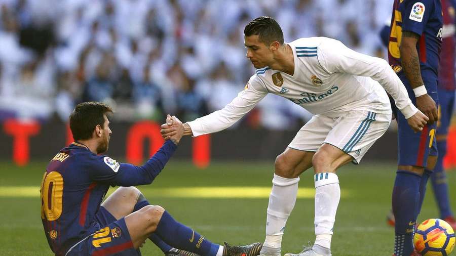 Jogadores de futebol apertando as mãos em um campo de grama durante uma partida. — Messi e Ronaldo 4K Papéis de Parede