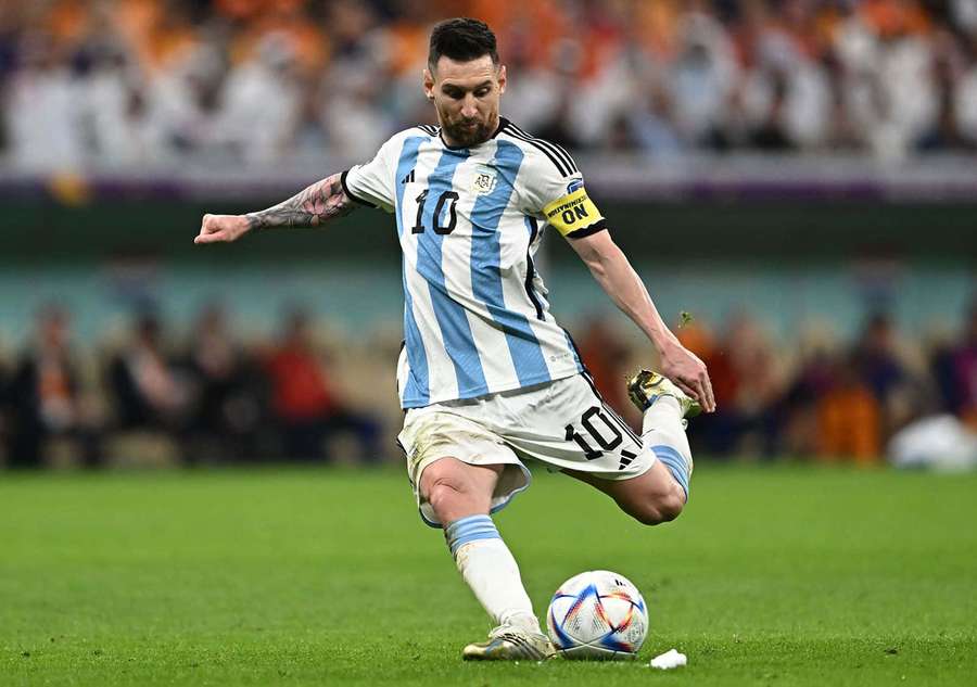 Lionel Messi con la camiseta de Argentina pateando un balón de fútbol en el campo de césped por la noche. — Messi Tiro Libre Fondos de pantalla