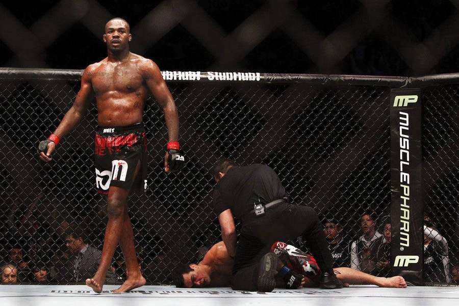 MMA-taistelija seisoo voitokkaana tyrmäyksen jälkeen kahdeksankulmiossa — Mestari Taustakuvat