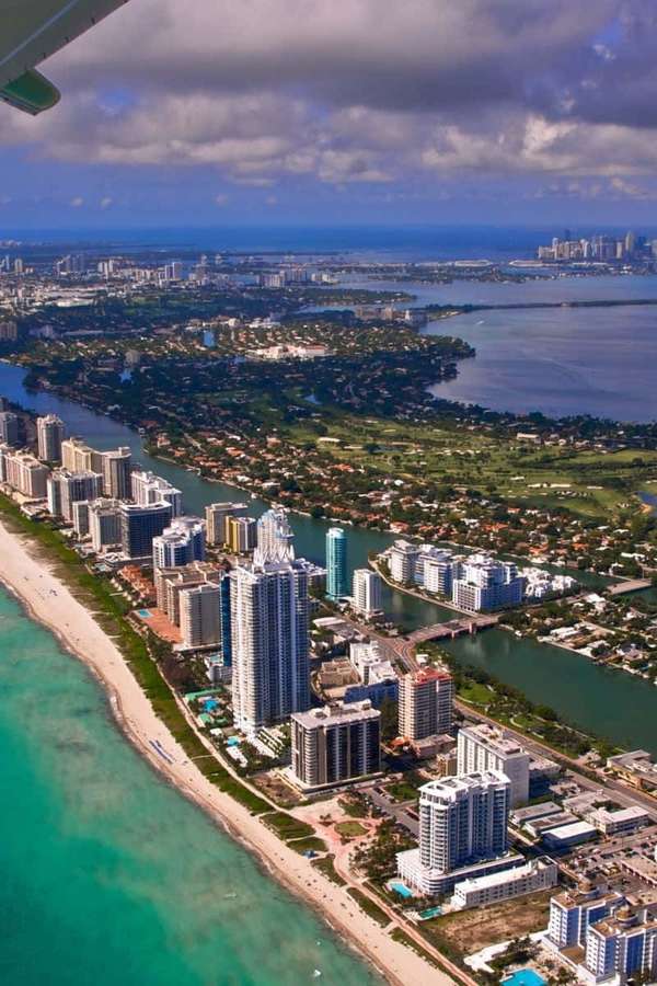 Aerial view of a coastal city with beaches and highrise buildings. — Miami iPhone Wallpaper