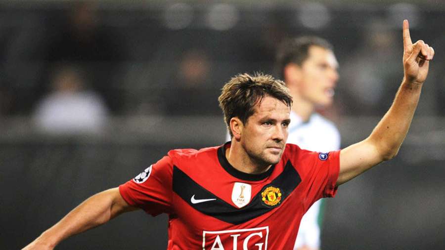 Pemain sepak bola merayakan dengan jersey merah Manchester United di stadion malam hari. — Michael Owen Wallpaper