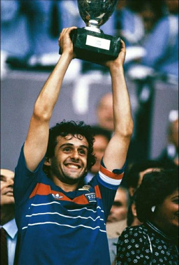 Soccer player holding trophy aloft in victory celebration — Michel Platini Wallpaper