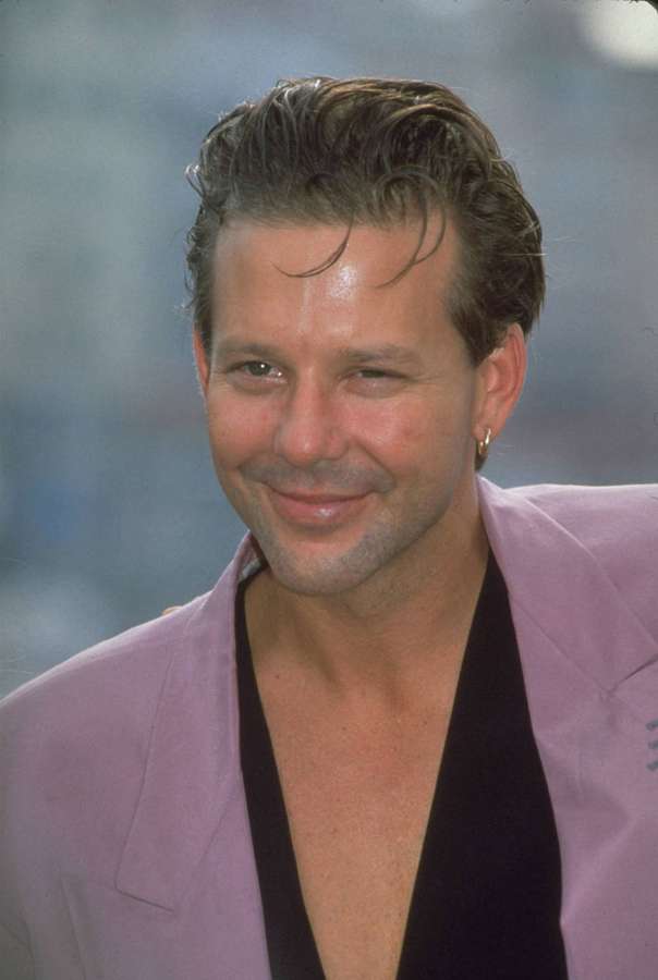 Mann in lavendelfarbenem Blazer lächelnd mit Ohrring — Micky Rourke Wallpaper