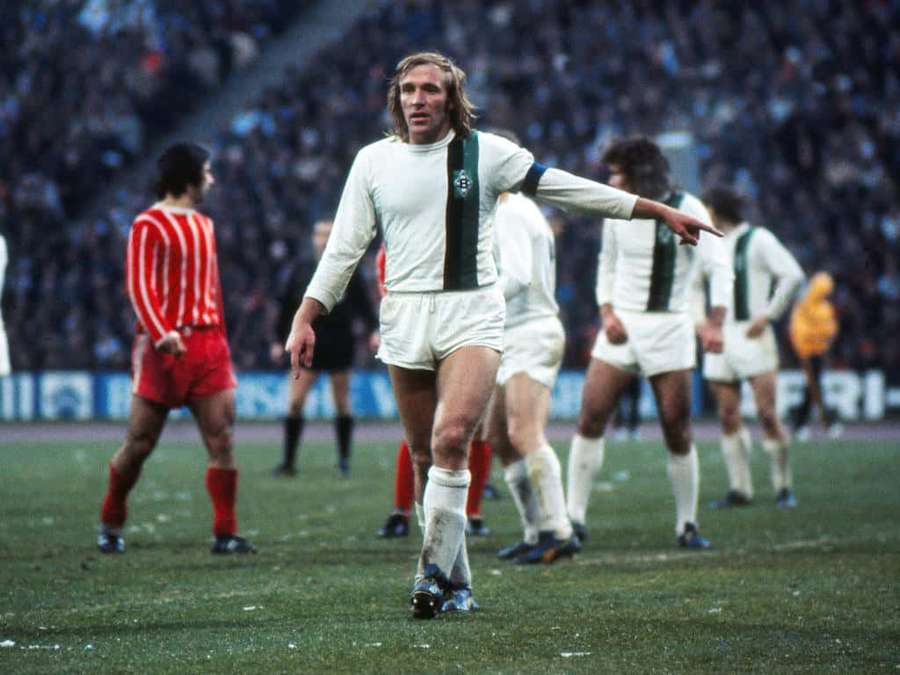 Vintage soccer player in white and green jersey gesturing on grass field during match. — Midfielder Picture