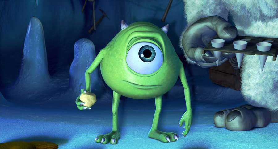 Green one-eyed monster holding cookie near furry creature offering drinks in cave. — Mike wazowski Wallpaper