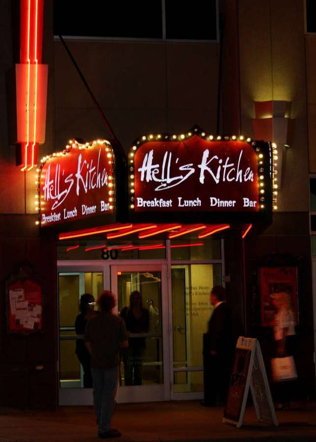Nachtszene des Hell's Kitchen Restaurants mit leuchtenden roten Neonlichtern und Menschen draußen. — Minneapolis Bilder