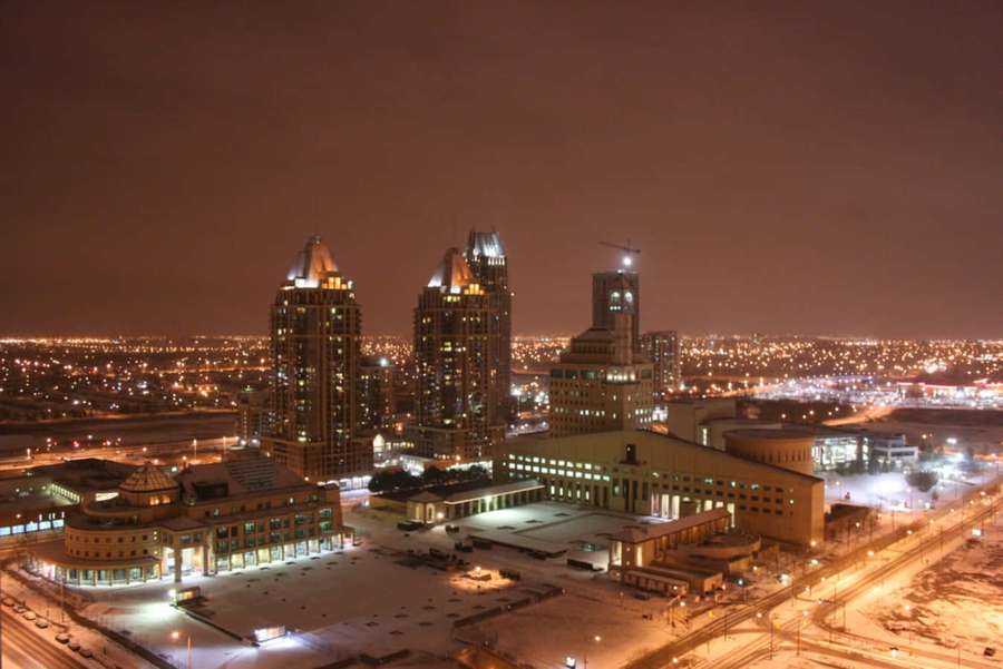 Snow-covered city at night with glowing buildings and streets. — Mississauga Wallpaper