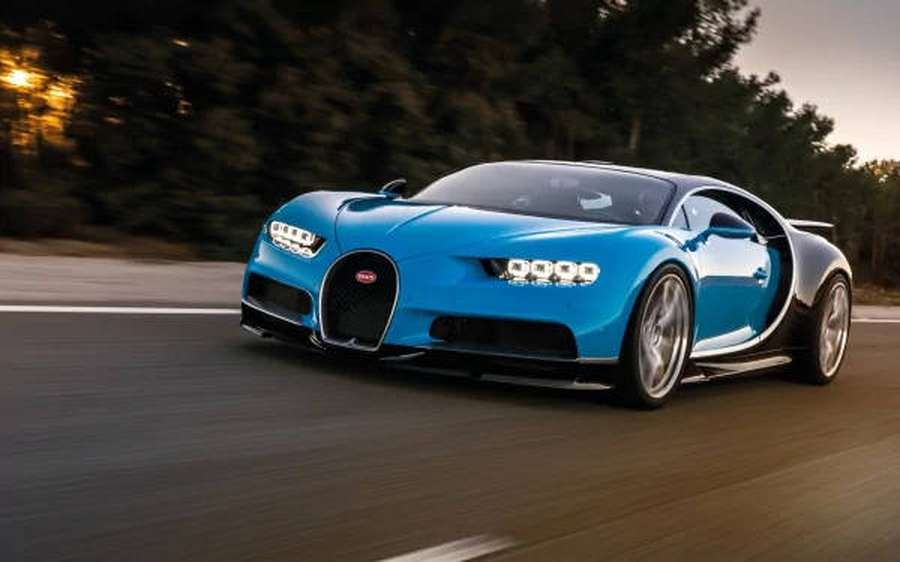 Um Bugatti Chiron azul acelerando em uma estrada ao entardecer. — Moção Papéis de Parede