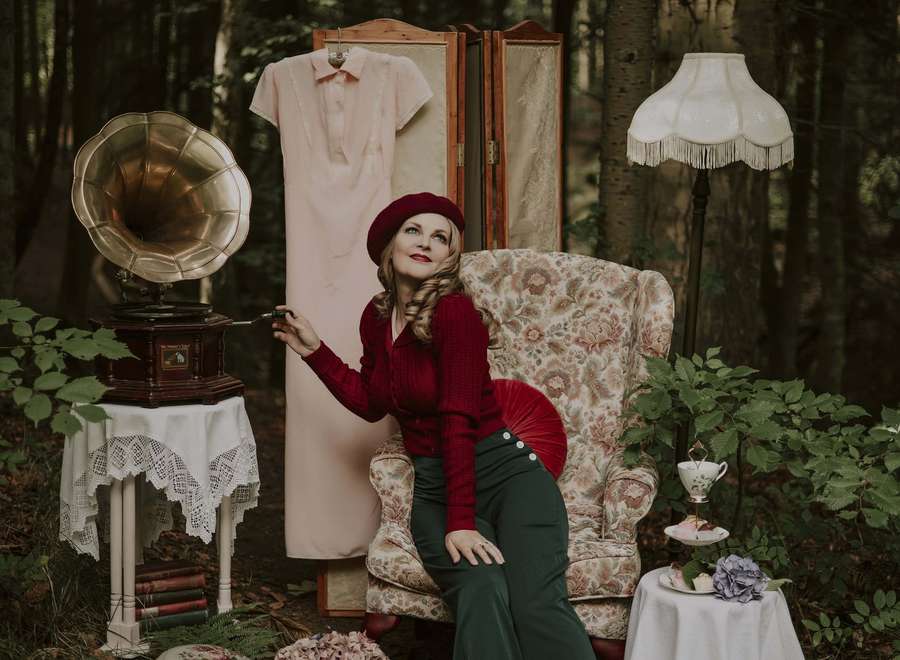 Mujer con vestido rojo y boina sentada en sillón floral con gramófono vintage en el bosque. — Moda Retro Fondo Fondos de pantalla