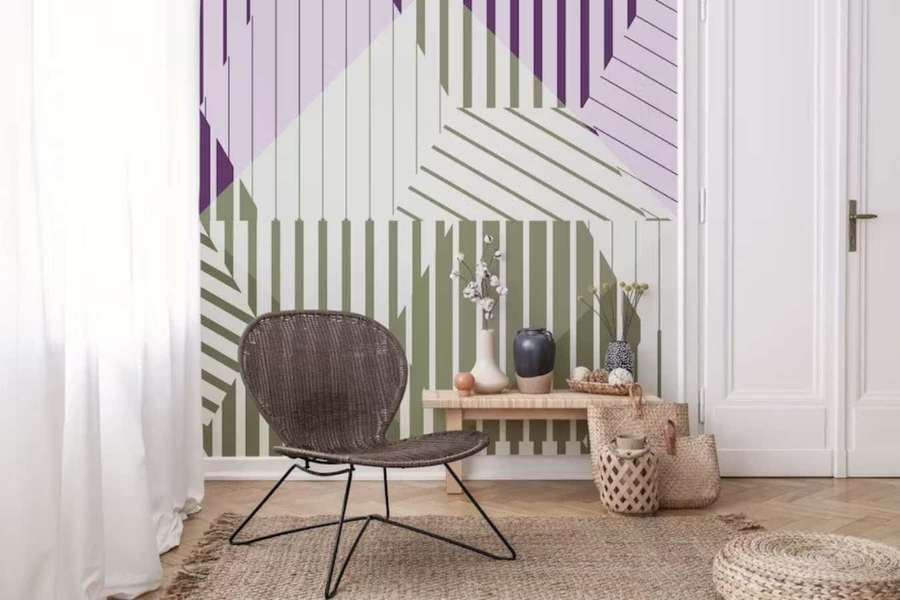 Wicker chair in front of geometric purple and olive green wallpaper in a minimalist room. — Modernism Wallpaper