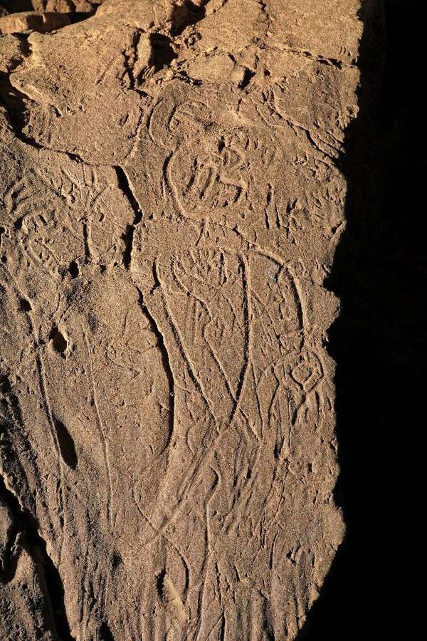 Close-up of ancient rock carvings with human and animal figures under sunlight. — Mudbound Wallpaper
