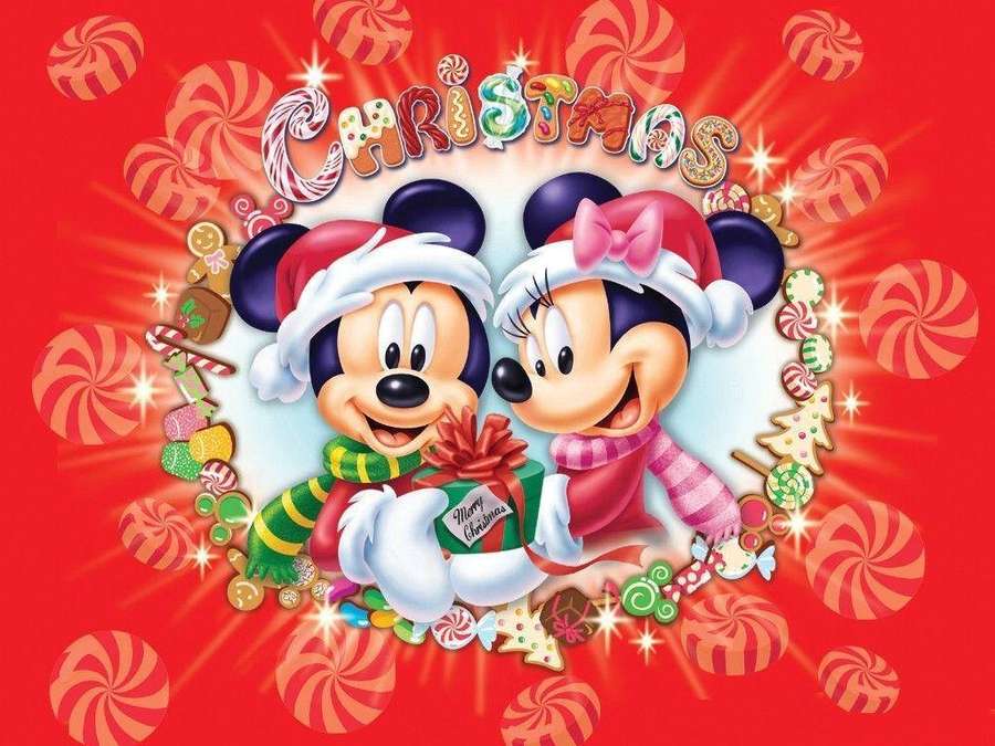 Mickey e Minnie em chapéus de Papai Noel segurando um presente de Natal cercado por doces. — Natal da Disney Papéis de Parede