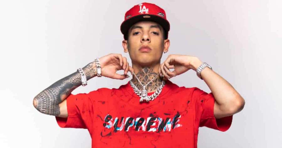 Young man in red Supreme shirt and LA cap posing with tattoos and jewelry. — Natanael Cano Wallpaper