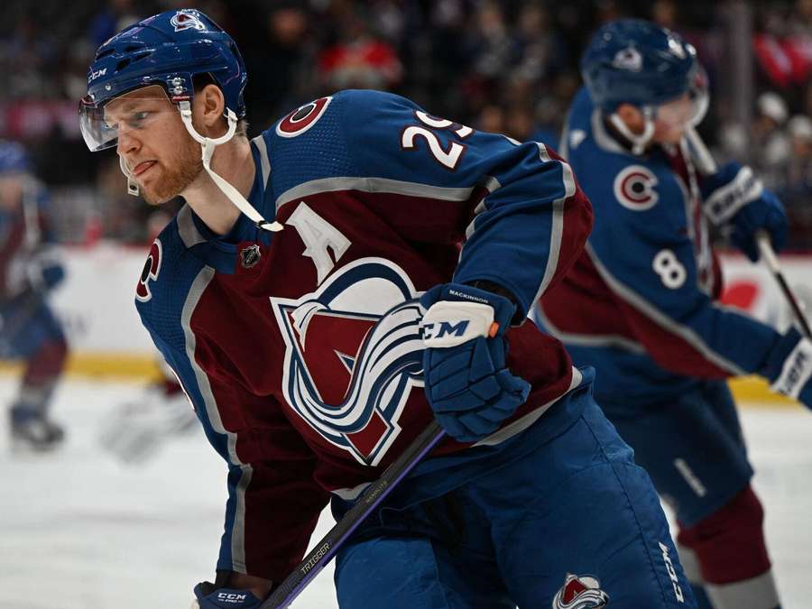 Hockey player in Colorado Avalanche uniform skating on ice during game. — Nathan Mackinnon Wallpaper