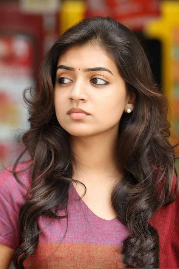 Young woman with long dark hair and pearl earring looking thoughtfully aside. — Nazriya HD Wallpaper