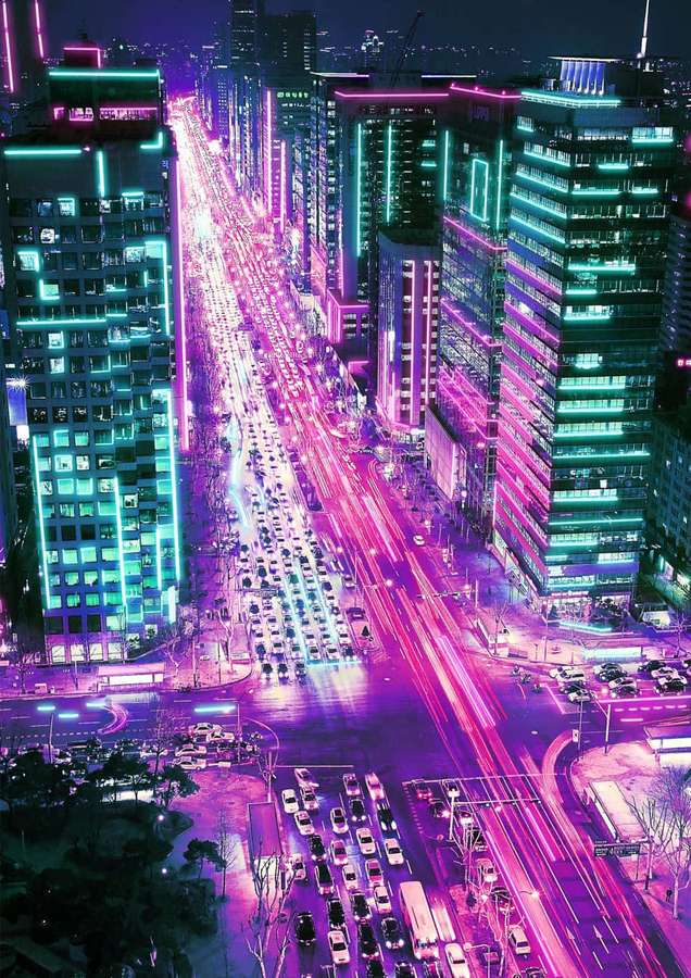 Neon-lit city street at night with streaking car lights and glowing skyscrapers. — Neon City Aesthetic Wallpaper