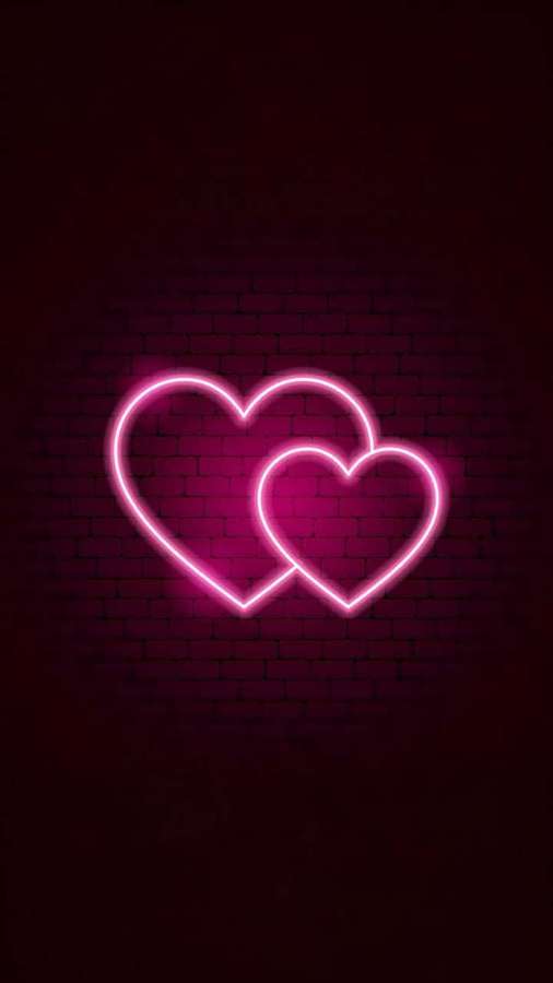 Zwei rosa Neonherzen, die auf einer dunklen Backsteinmauer leuchten. — Neonherz Wallpaper