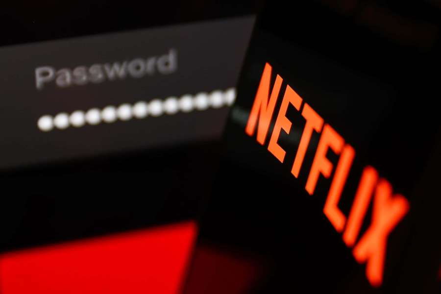 Phone screen showing Netflix login with password field and glowing orange logo. — Netflix Picture