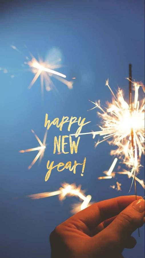 Hand holding sparkler with 'happy new year' text against blue sky — New Year Phone Wallpaper