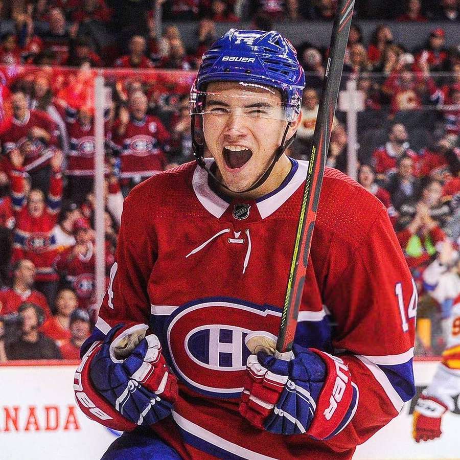 Hockey player in red jersey celebrating victory with crowd in background. — Nick Suzuki Wallpaper