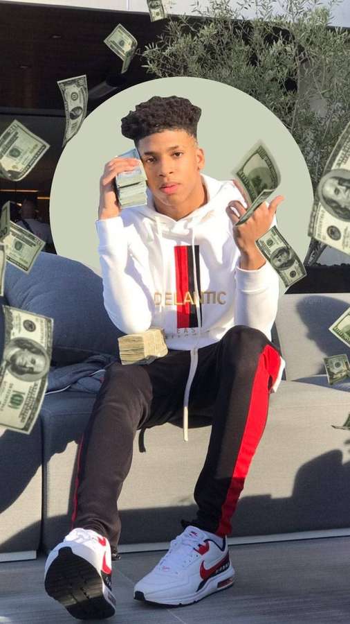 Young man sitting on couch surrounded by falling dollar bills. — Nle Background