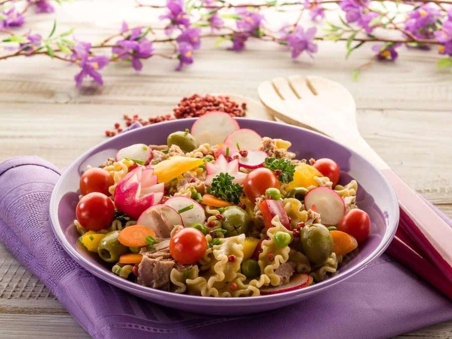 Fargerik pastasalat med grønnsaker på en lilla tallerken med blomster og trebestikk. — Nudler Bakgrunner