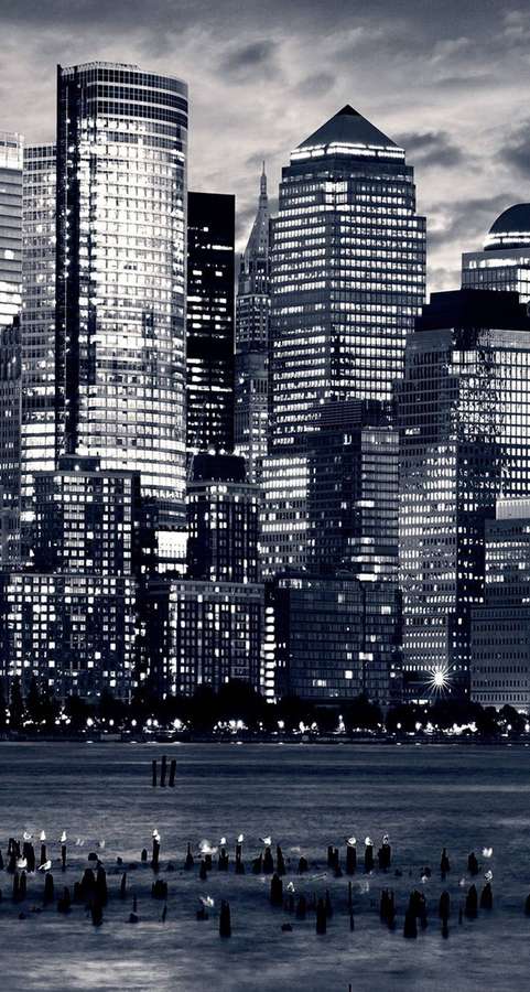 Dusk city skyline with lit skyscrapers reflected in water. — Nyc Phone Wallpaper