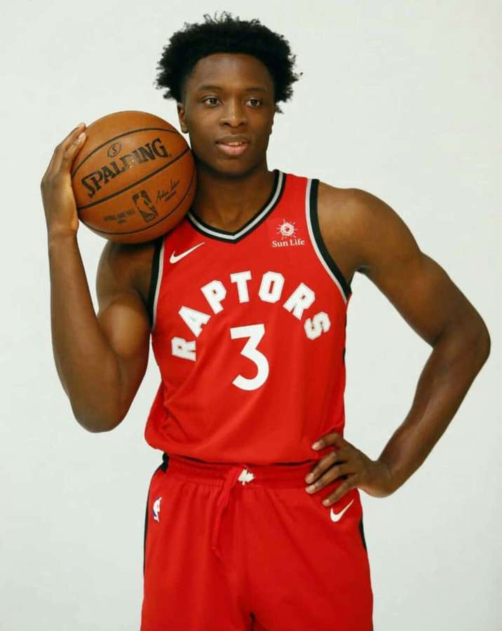Professional basketball player in red Raptors jersey holding a Spalding basketball. — Og anunoby Wallpaper