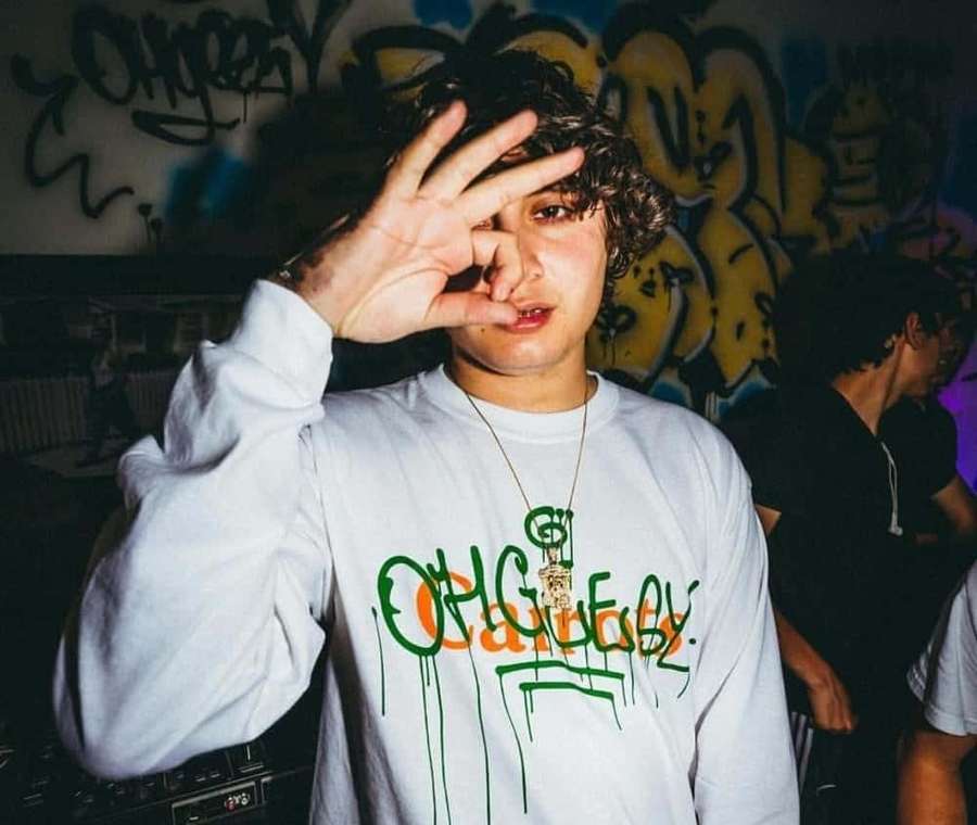 Ung person i hvid sweatshirt laver øjenbevægelse i graffiti-gyde om natten. — Ohgeesy Wallpapers