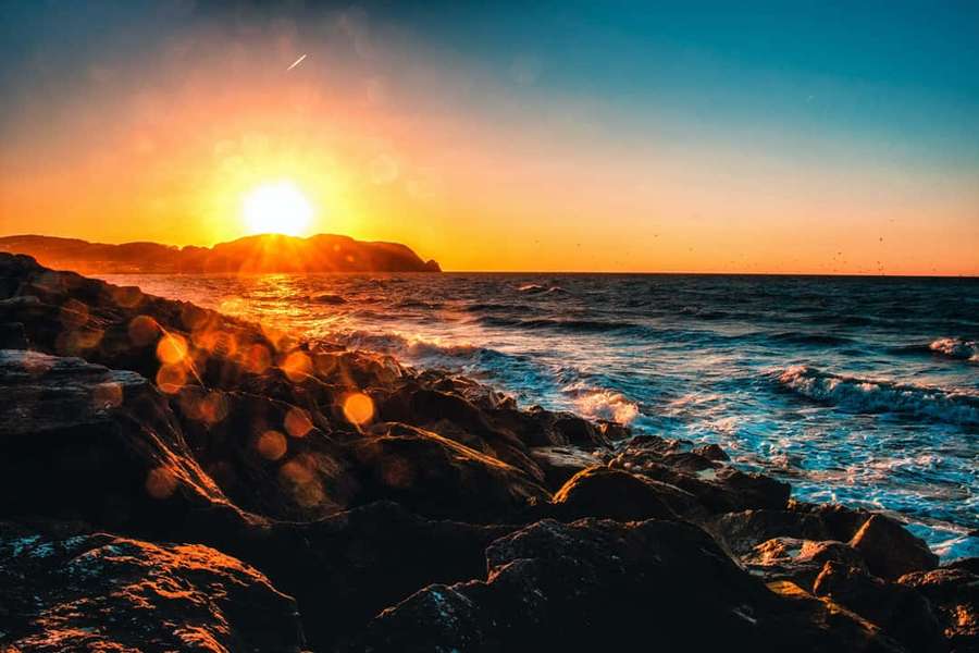 Atardecer sobre costa rocosa con olas rompiendo y luz dorada — Olas del atardecer Fondos de pantalla
