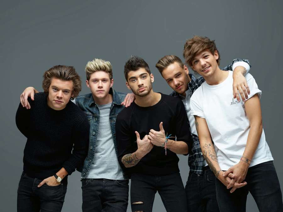 Fünf junge Männer posieren gemeinsam in einem Studio mit den Armen umeinander. — One Direction Bilder