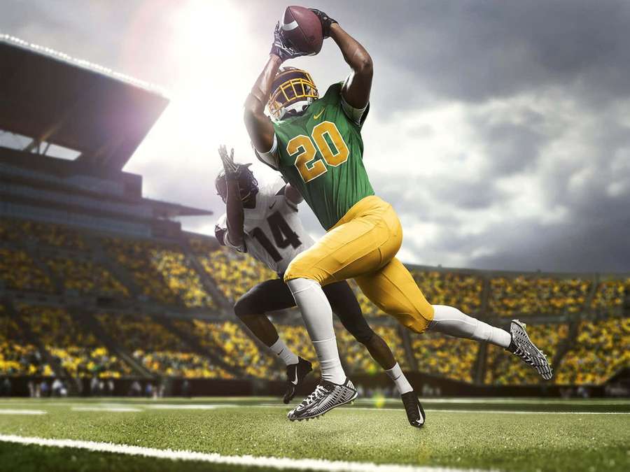 Football player catching ball in stadium with crowd — Oregon Ducks Wallpaper