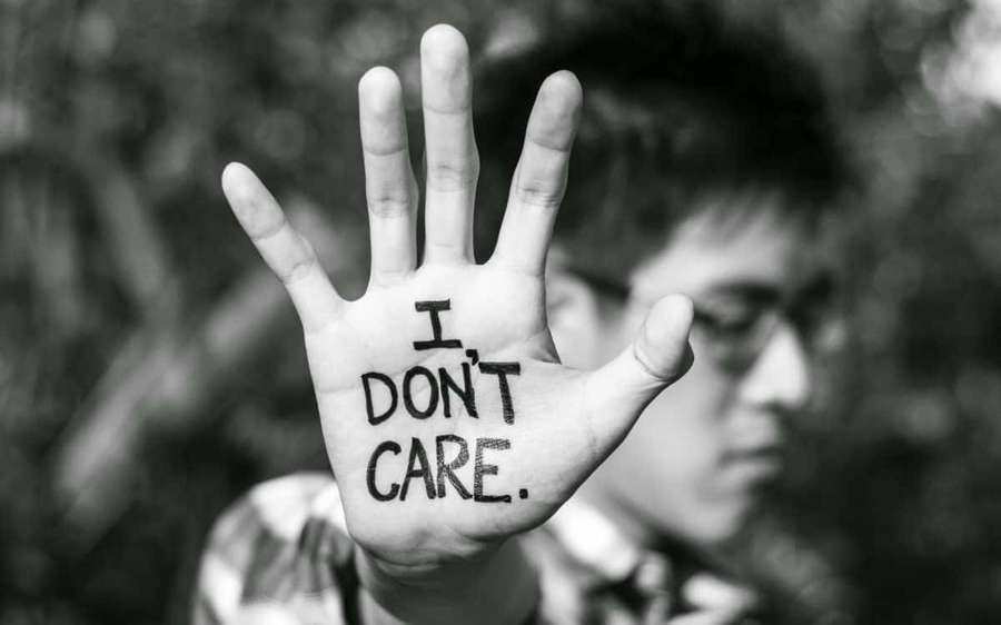 Person holding up hand with 'I DON'T CARE' written on palm. — Ornery Wallpaper