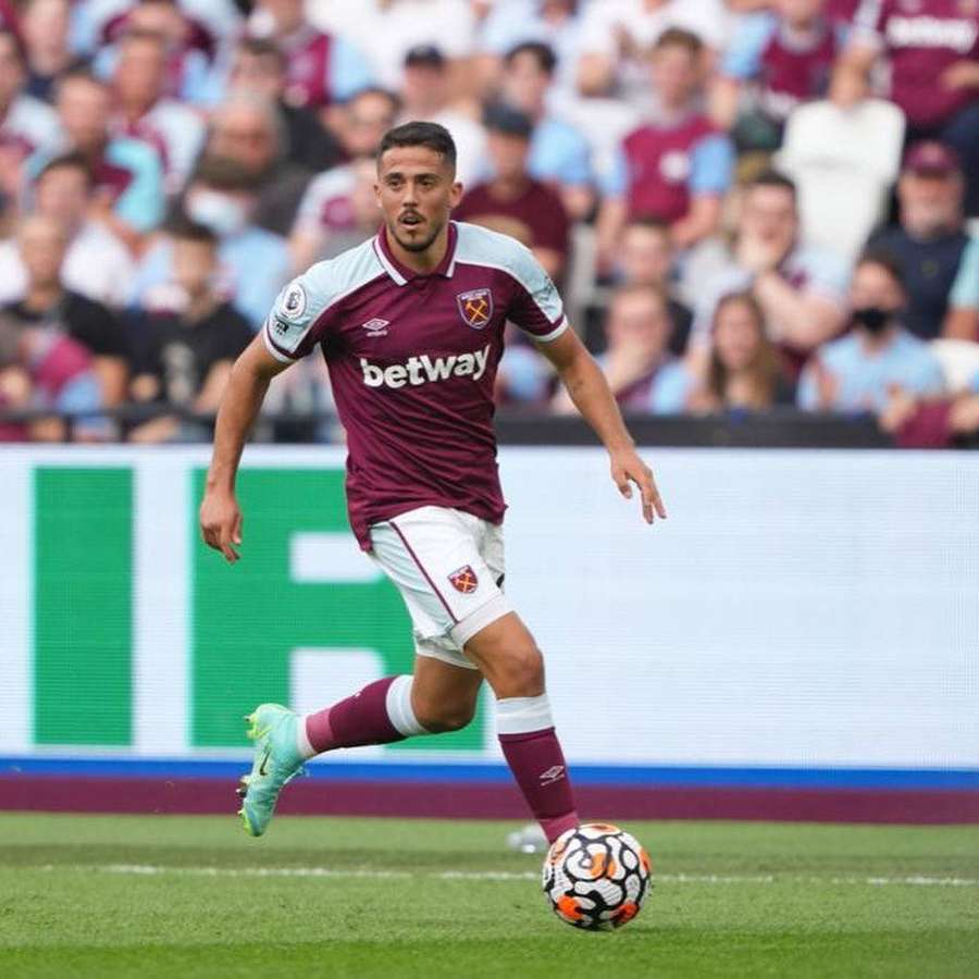 Football player dribbling ball on grass field during daytime match with crowd behind. — Pablo Fornals Wallpaper