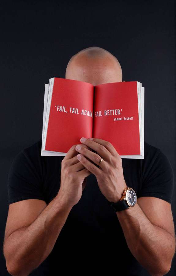 Hombre sosteniendo libro rojo abierto con cita fail fail again fail better — Página Fondos de pantalla