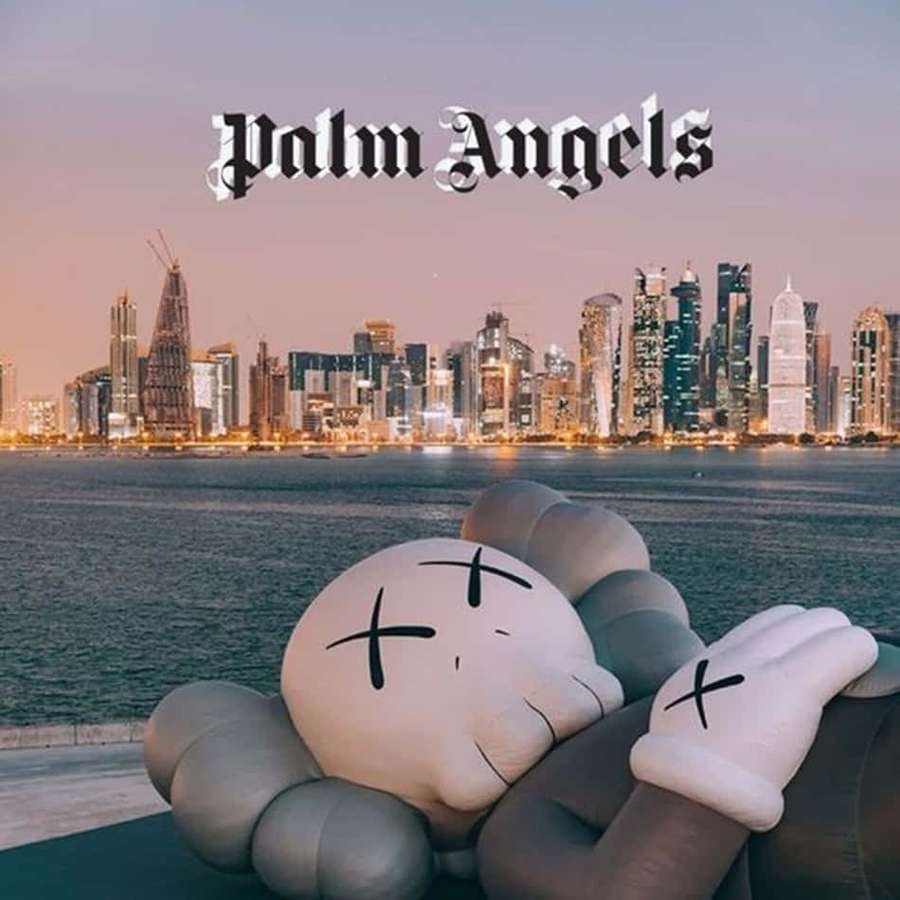Große KAWS-Skulptur mit Blick auf die Stadtsilhouette in der Abenddämmerung. — Palmengel Wallpaper