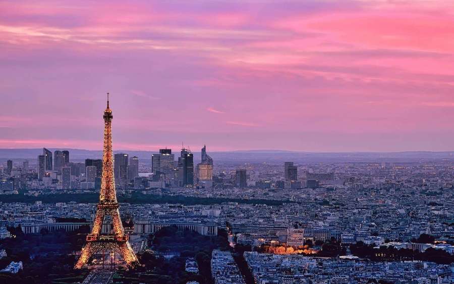 Eiffelturm bei Dämmerung beleuchtet mit rosa Himmel über Pariser Stadtsilhouette — Pariser Eiffelturm Wallpaper