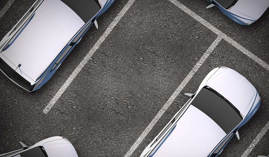 White cars parked in a marked asphalt lot from an overhead perspective. — Parking Background