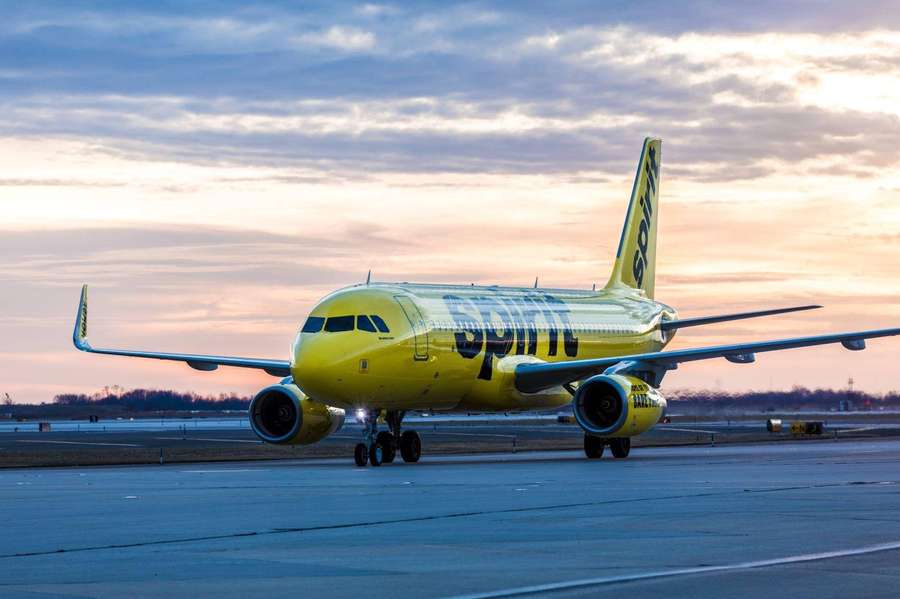 Avião amarelo da Spirit Airlines na pista ao pôr do sol — Passarela Papéis de Parede
