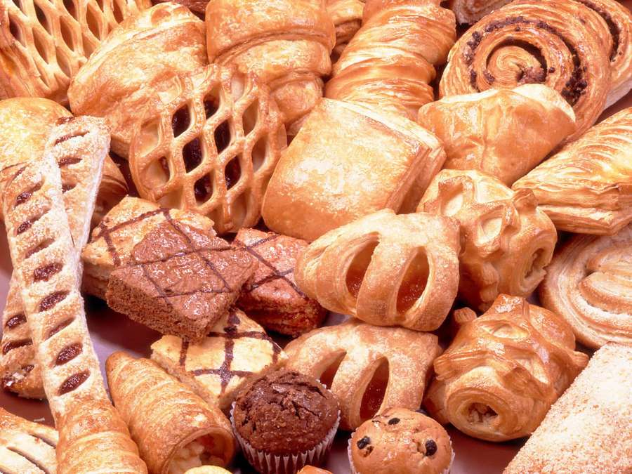 A pile of assorted golden-brown pastries and sweet baked goods. — Pastry Background