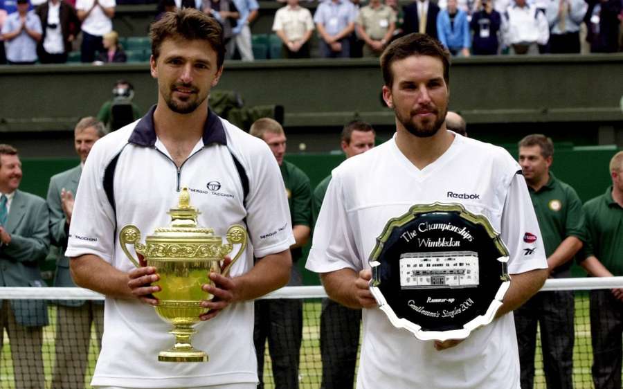 Zwei männliche Tennisspieler halten die Wimbledon-Meisterschaftstrophäe und die Zweitplatzierte-Platte auf dem Rasenplatz. — Patrick Rafter Bilder