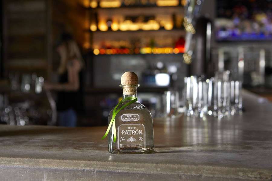 A Patron Silver tequila bottle on a bar with blurred background. — Patron Wallpaper