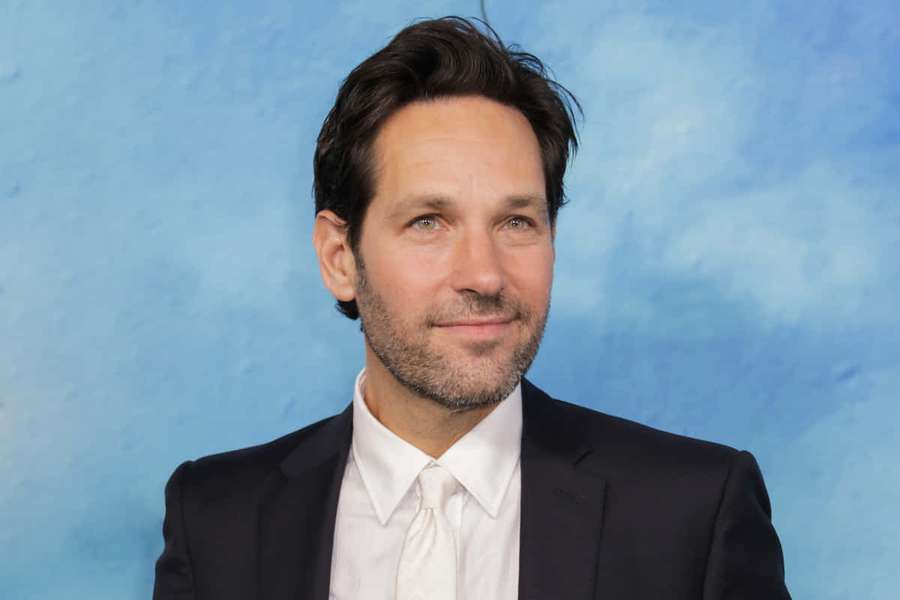 Hombre con traje sonriendo contra fondo azul texturizado — Paul rudd Fondos de pantalla