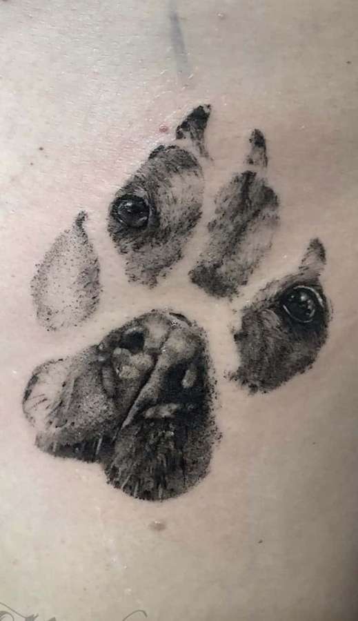 Ein Hundepfoten-Tattoo mit Augen in den Ballen auf der Haut einer Person. — Paw Print Bilder