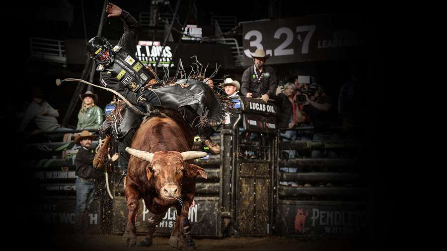 Bull rider in helmet and vest holds on tight as bull bucks in rodeo arena at night. — Pbr Wallpaper