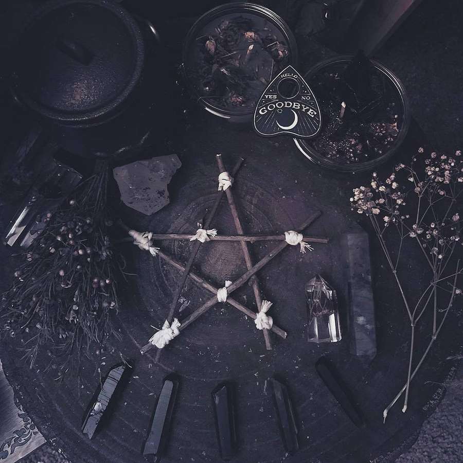 A dark pentagram ritual setup with crystals dried herbs and a spirit board. — Pentagram Background