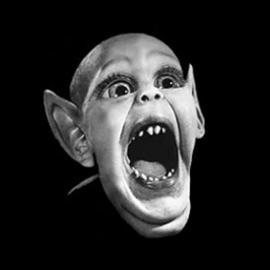 Un rostro de duende gritando con ojos muy abiertos y dientes afilados en blanco y negro. — Perfil extraño Imágenes