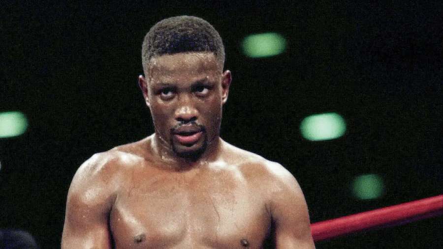 A focused boxer in a ring with green lights behind him. — Pernell Whitaker Wallpaper