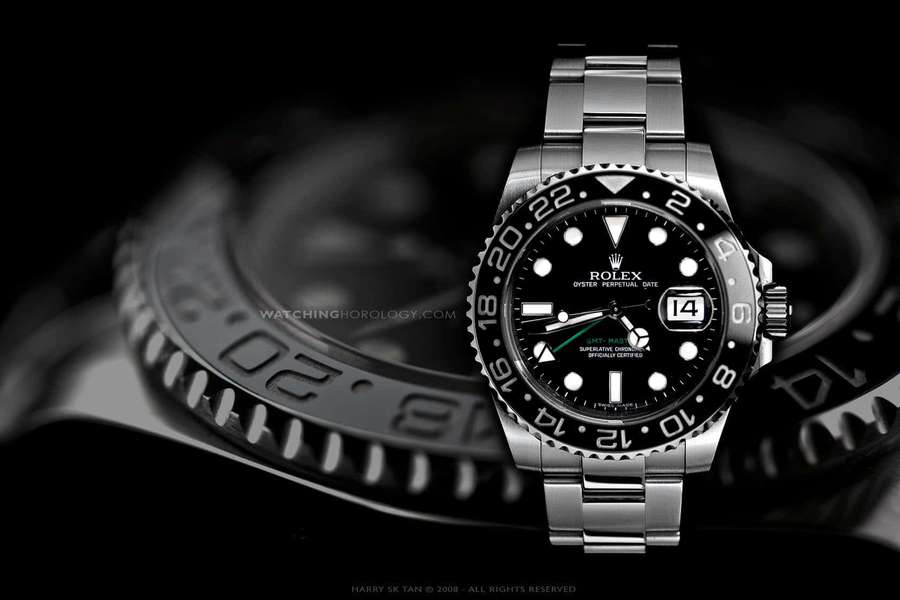 Close-up de um relógio de luxo Rolex GMT-Master II com mostrador preto e ponteiro verde. — Perpétuo Papéis de Parede